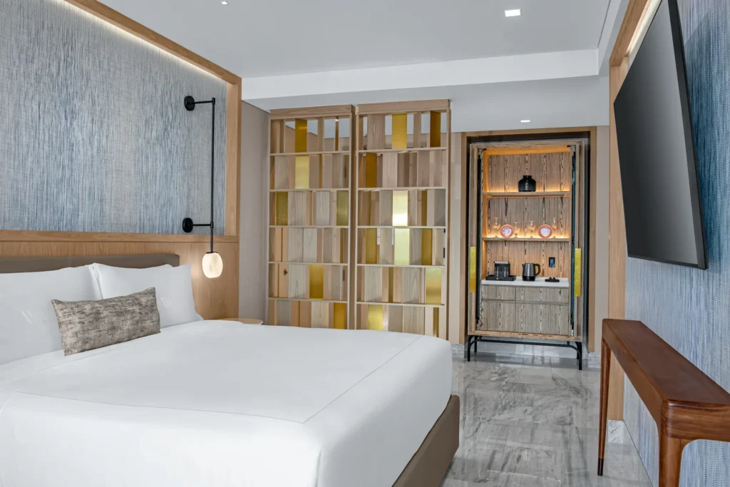 Elegant bedroom in the DELUXE OCEANFRONT KING BED GUESTROOM, offering comfort and sophisticated ocean-inspired décor