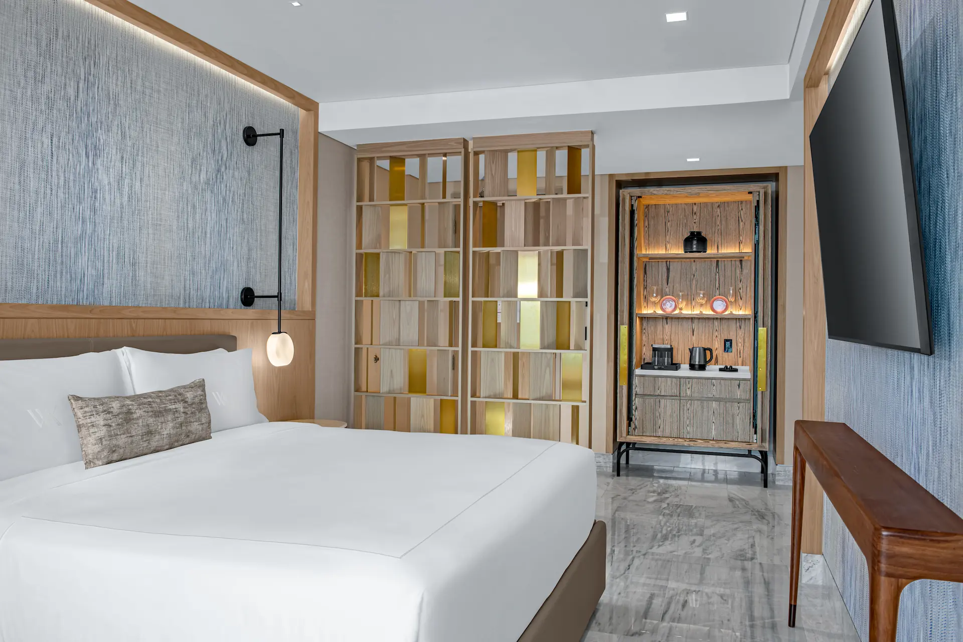 Elegant bedroom in the DELUXE OCEANFRONT KING BED GUESTROOM, offering comfort and sophisticated ocean-inspired décor