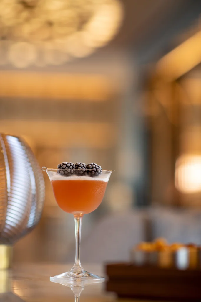 Elegant cocktail glass with fresh blackberries, a refined and flavorful experience at Waldorf Astoria Cancun