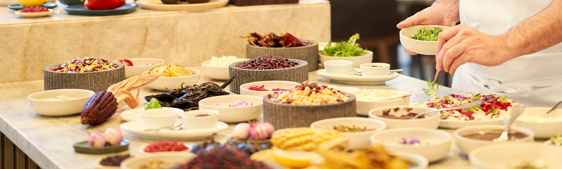 Chef preparing a dish with fresh, local ingredients at Waldorf Astoria Cancun.