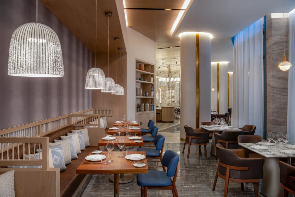 Elegante interior del restaurante Chaya del Waldorf Astoria Cancún, con un diseño sofisticado y un ambiente acogedor.