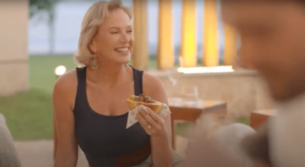 Smiling guest tasting a dish in a bright dining space