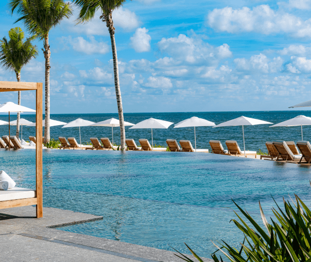Una piscina infinita en el Waldorf Astoria Cancún con el océano de fondo, creando un ambiente sereno y lujoso.