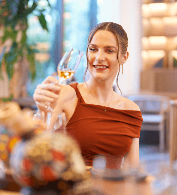 An elegant woman enjoying a glass of champagne at Waldorf Astoria, exuding sophistication.