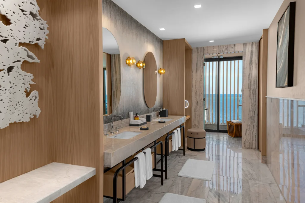 Elegant bathroom with double sinks and a window in the DELUXE OCEAN FRONT 2 QUEEN BEDS GUESTROOM, offering a bright, spacious, and luxurious ambiance