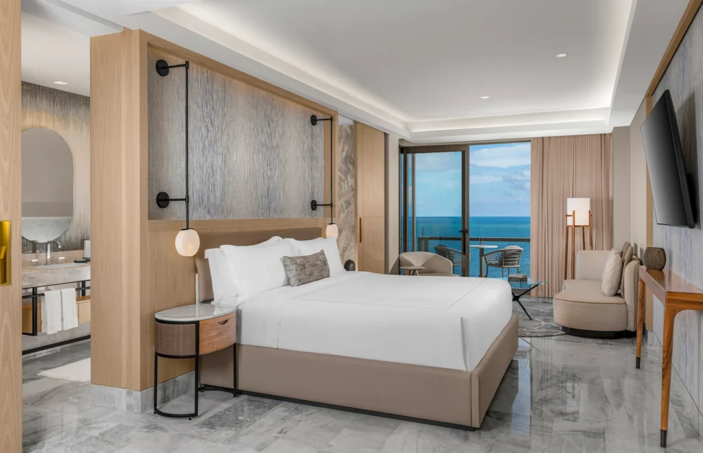 Ocean-view bedroom in the DELUXE OCEANFRONT SUITE WITH KING BED, featuring elegant décor and a peaceful ambiance