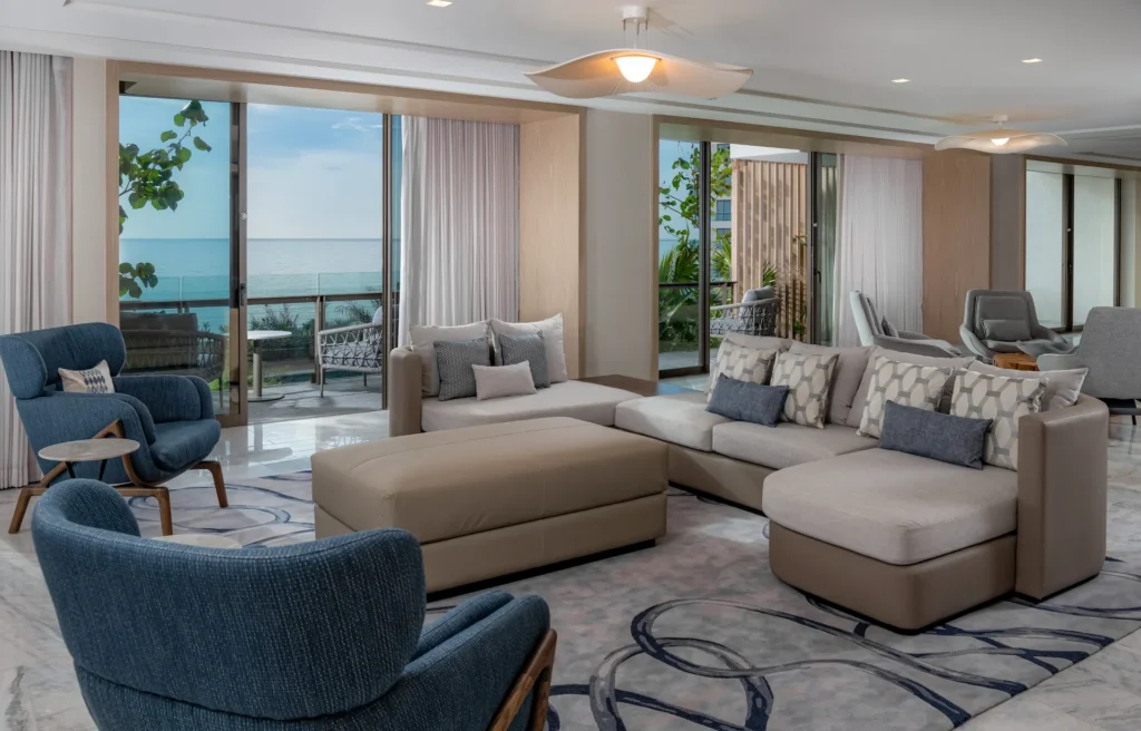 Spacious living area with a large sofa and balcony in the OCEANFRONT 2 BEDROOM PRESIDENTIAL SUITE, providing a comfortable and luxurious space with breathtaking ocean views.