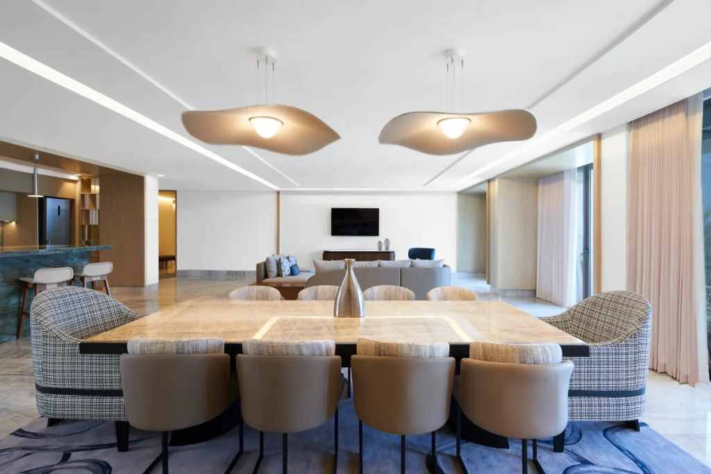 Dining area, living room, and kitchen in the AMAI Suite, featuring stylish décor and an open, spacious layout for a luxurious and comfortable experience