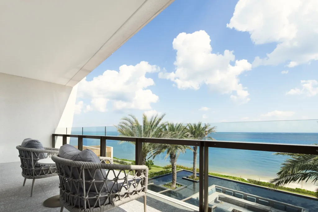Balcony of the AMAI Suite with stunning views of the pool and ocean, offering a serene and luxurious outdoor retreat