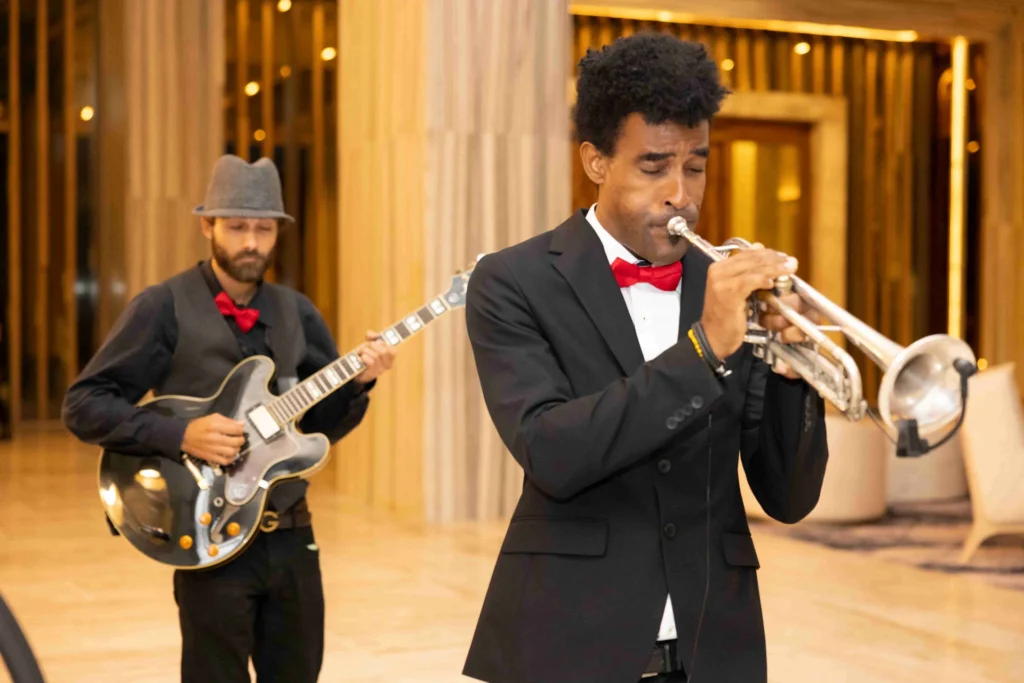 Two musicians playing a trumpet and guitar, creating a lively and harmonious atmosphere