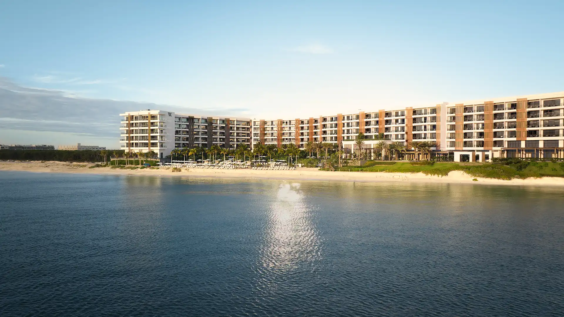 La impresionante fachada completa del complejo Waldorf Astoria Cancún en México, con vistas a una playa virgen de arenas doradas y aguas turquesas.