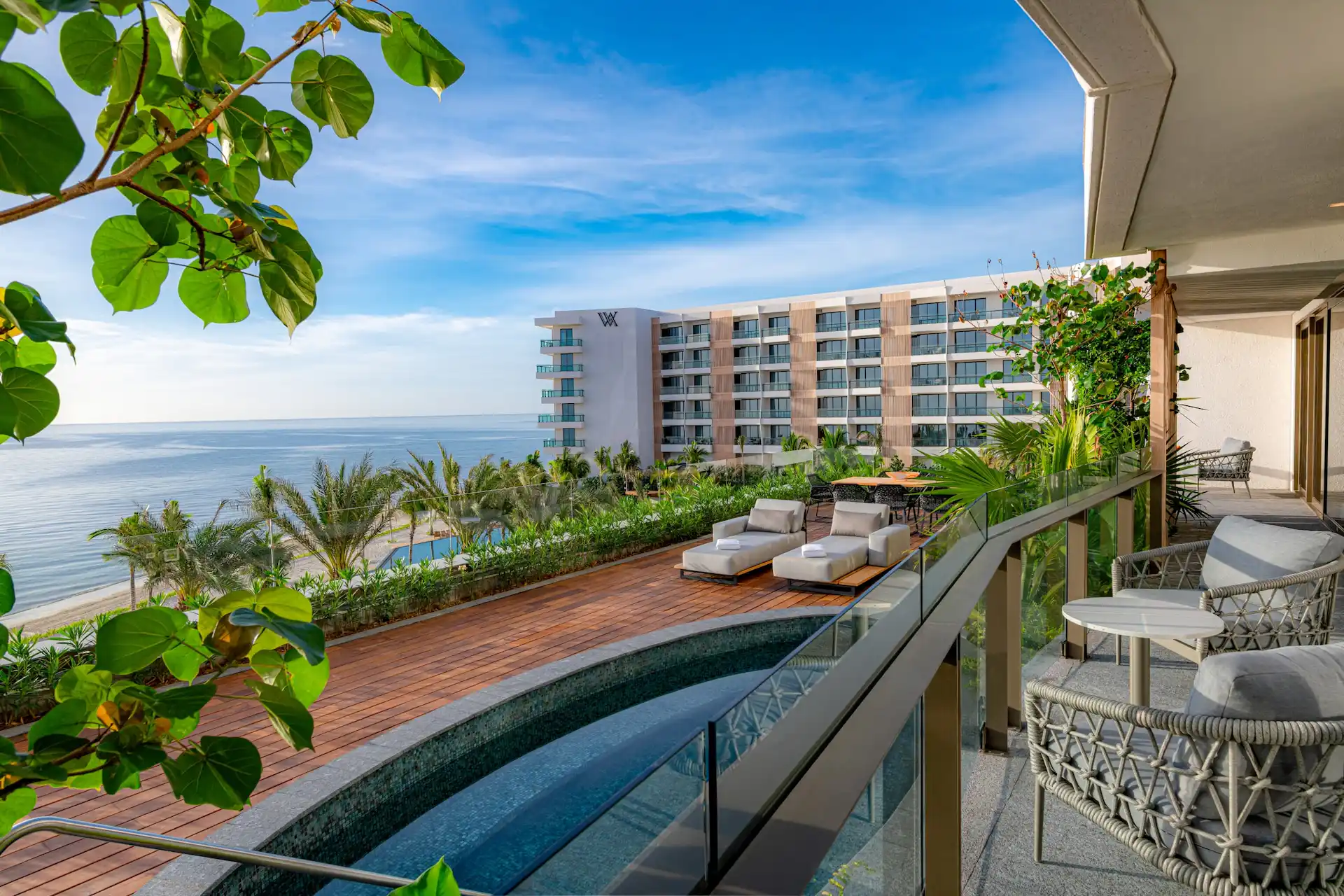 A beautiful view from a balcony at Waldorf Astoria Cancun, overlooking the facade, the pool, and the beach.